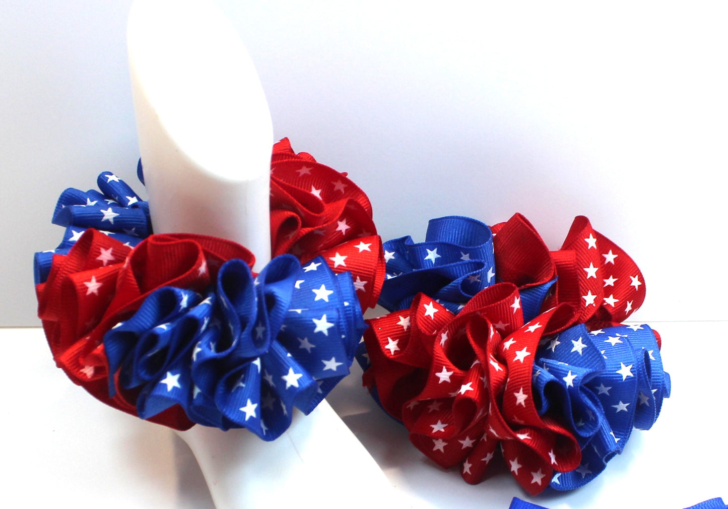 Red, white, and blue decorative bows with star patterns on a white background