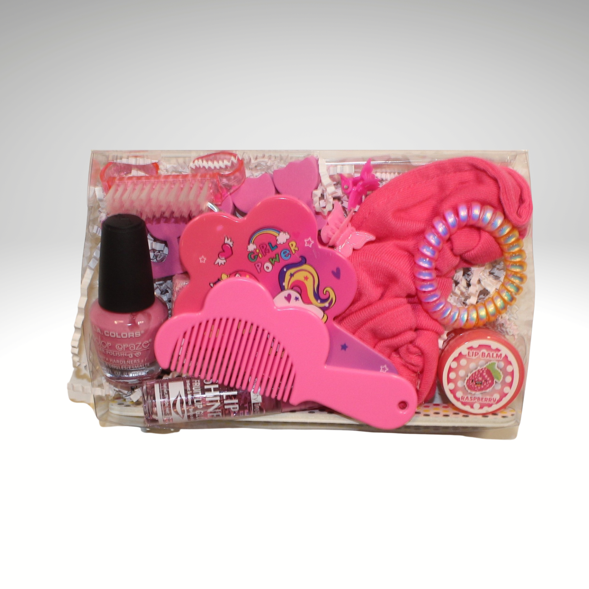 Pink hair care and beauty product set with nail polish, comb, and hair ties on a white background