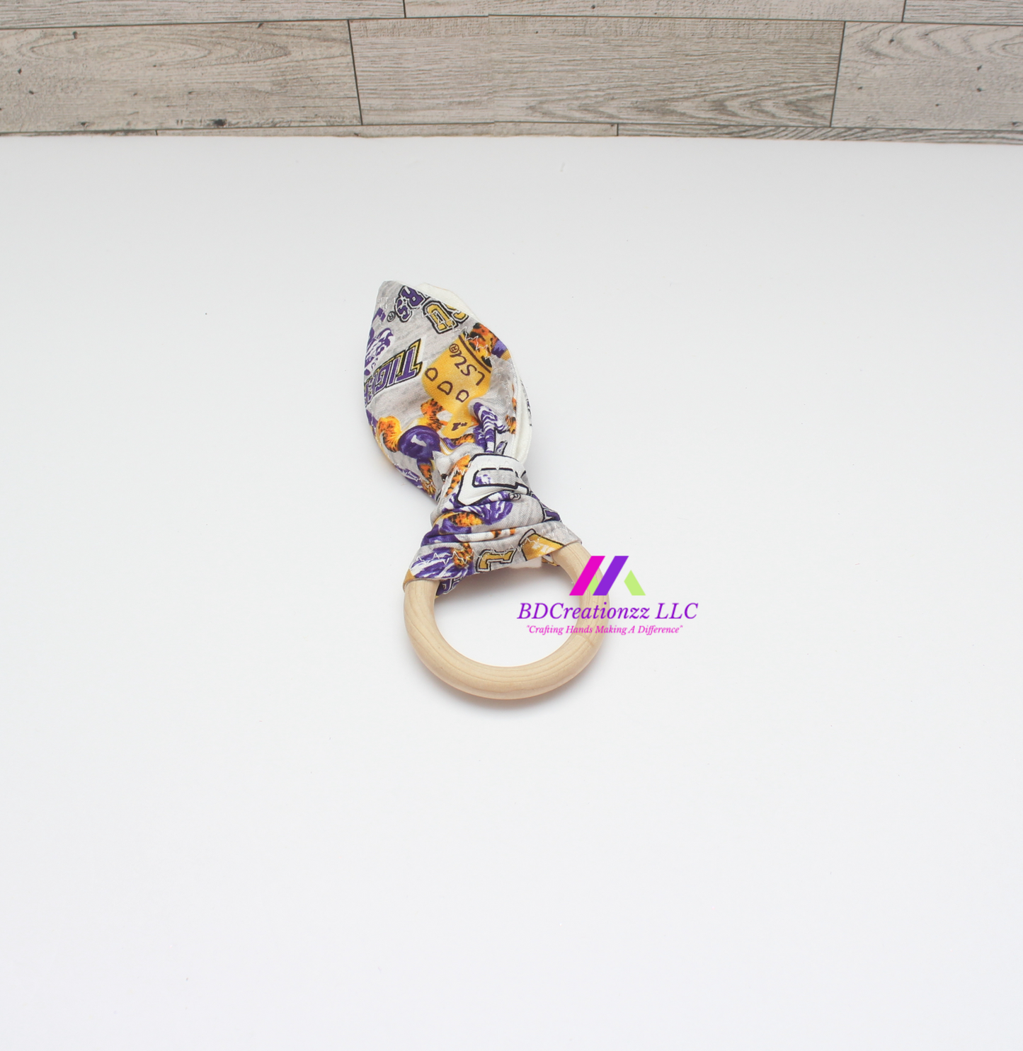 Football print wooden teether ring with soft fabric ears for babies.