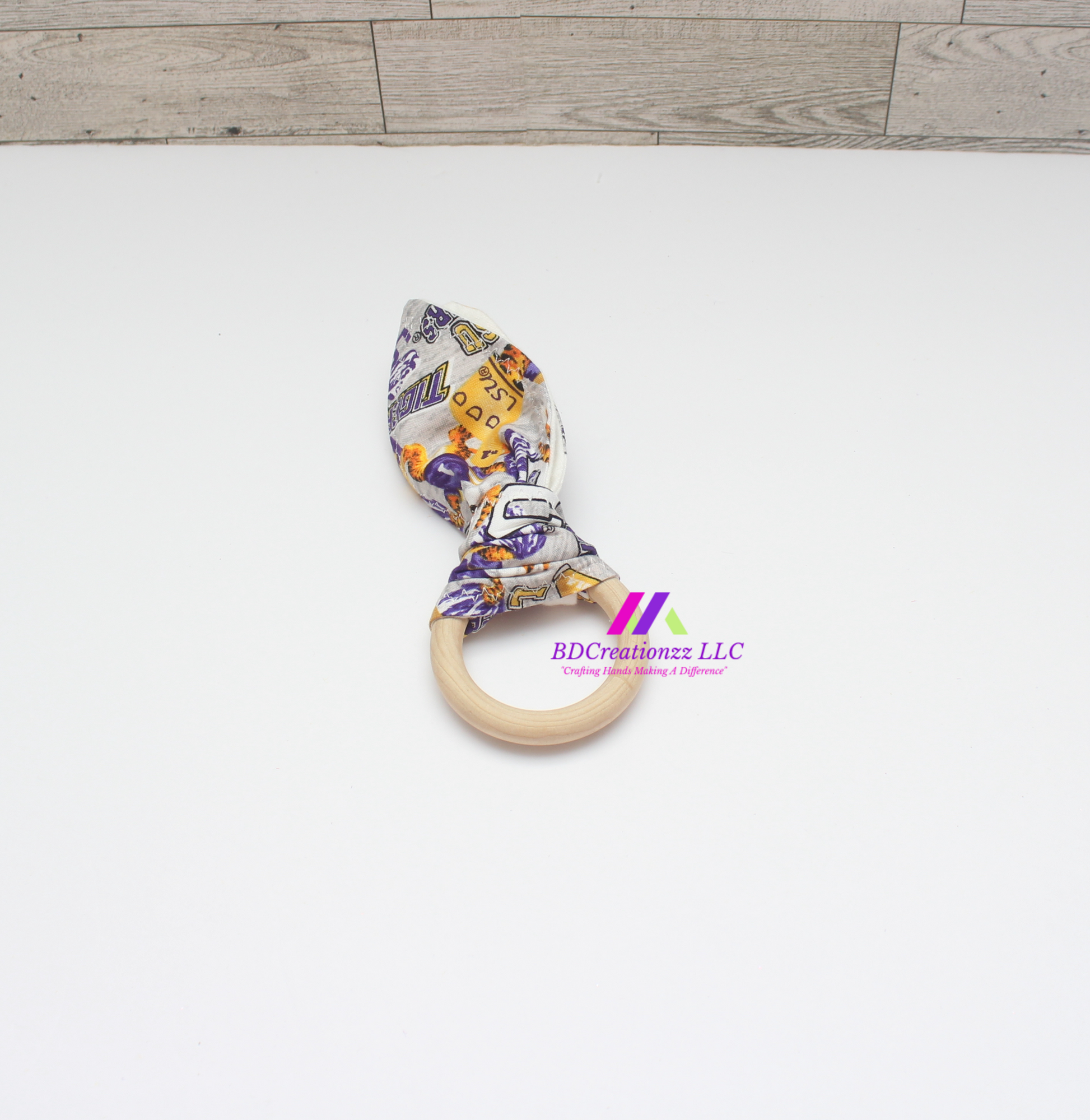Football print wooden teether ring with soft fabric ears for babies.