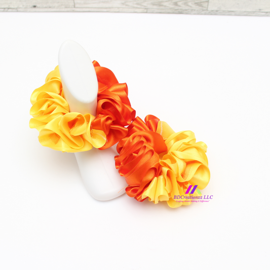 Front view of bright orange and yellow detachable ruffle socks for babies and toddlers, soft and colorful